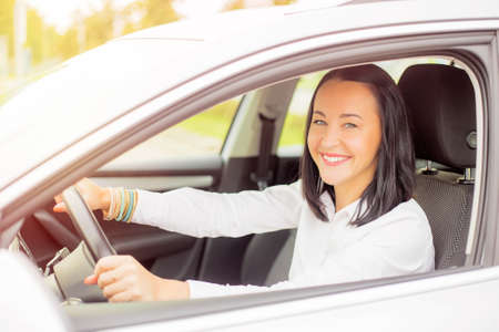 Woman in the car sitting and smilingの写真素材