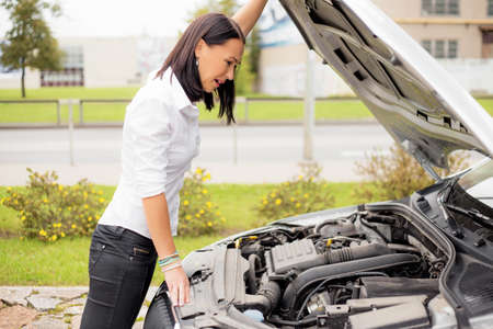 Woman looking at broken cars motorの写真素材