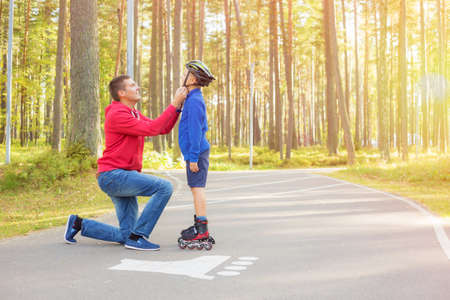 Father closing his sons helmetの写真素材