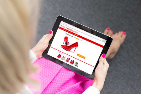 Woman using tablet to buy shoes onlineの写真素材