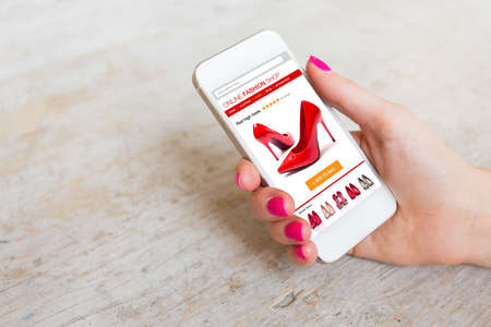 Woman using smartphone to buy shoes onlineの写真素材