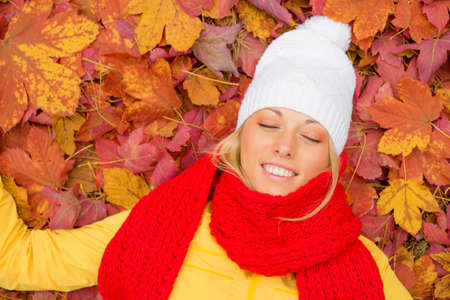 Woman with her eyes closed laying in leafsの写真素材