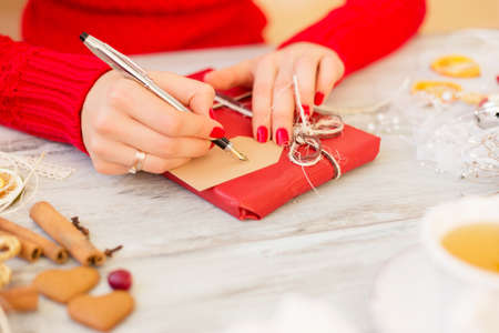 Woman preparing present and writing on the cardの写真素材
