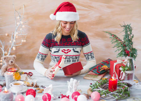 Happy woman wrapping Christmas present boxの写真素材