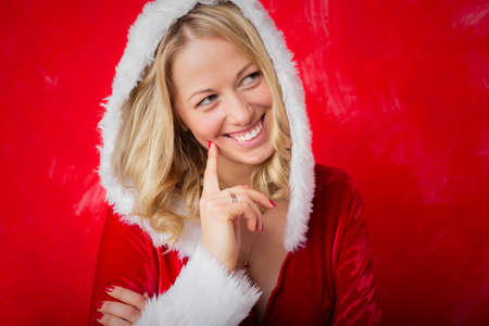 Woman in red Santa costume being thoughtfulの写真素材