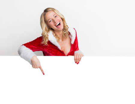 Happy woman in Christmas costume pointing at somethingの写真素材