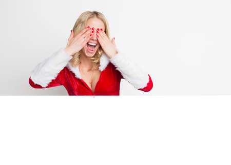 Woman in red Christmas costume covering her eyesの写真素材