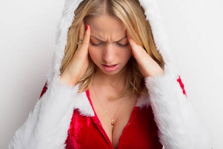 Stressed woman in red costume holding her headの写真素材