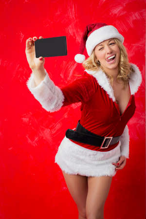 Woman in sexy Santa costume taking selfieの写真素材