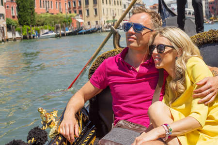 Happy couple sitting in gondola on their vacationの写真素材