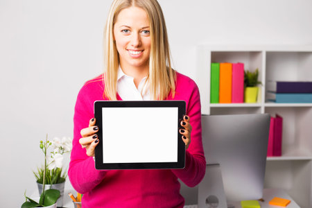 Woman in colorful sweater holding tablet with blank screen