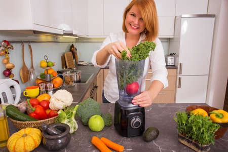 Woman blending vegetablesの写真素材