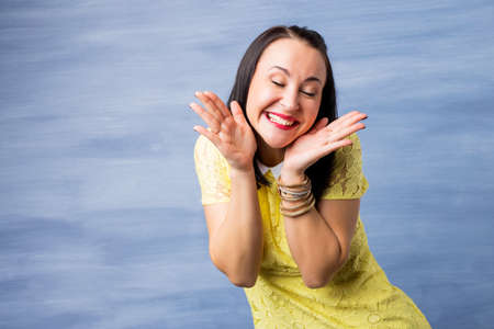Happy and excited woman holding her faceの写真素材