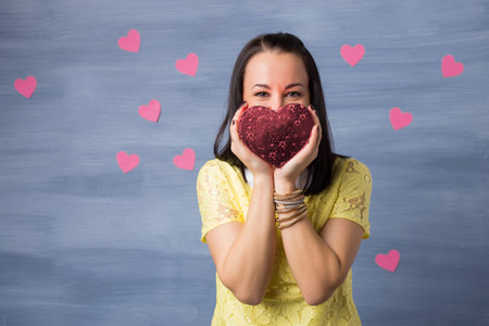 Woman in love holding heart shaped gift box