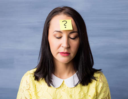 Woman with sticky note on her foreheadの写真素材