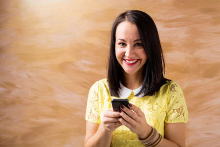 Woman smiling and using her smartphoneの写真素材
