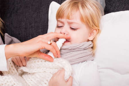 Child using medicine to treat coldの写真素材