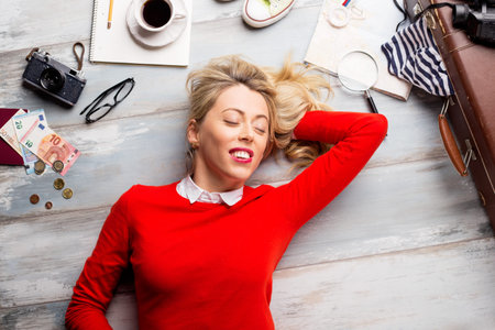 Woman lying on ground and dreaming about traveling