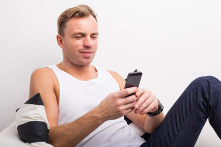 Man sitting on sofa and textingの写真素材