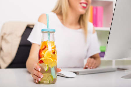 Woman at the office having re-freshening drinkの写真素材