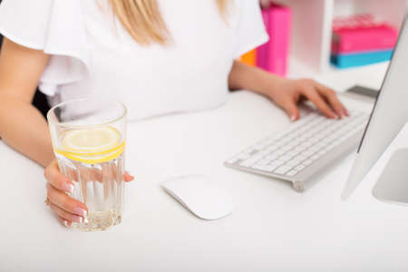 Woman having water with lemon at the officeの写真素材