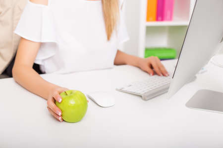 Woman and healthy snack in officeの写真素材