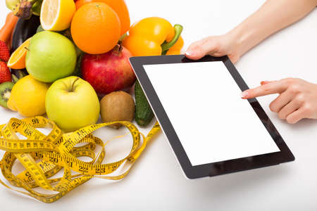 Tape measure, vegetables, and tablet with blank screenの写真素材