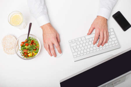 Man working and having healthy lunchの写真素材