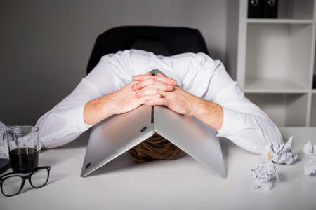Man hiding under laptopの写真素材