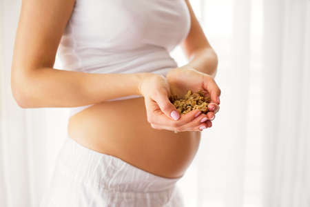 Pregnant woman holding nutsの写真素材