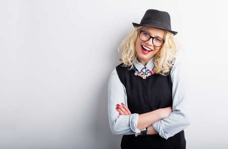 Hipster woman leaning against the wall with crossed handsの写真素材