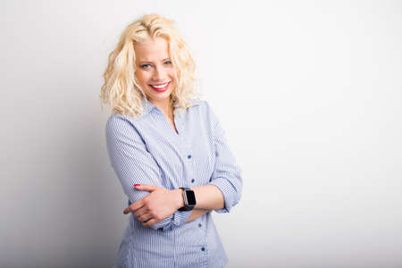 Happy woman standing with crossed hands on white backgroundの写真素材