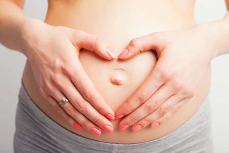 Pregnant woman with heart signの写真素材