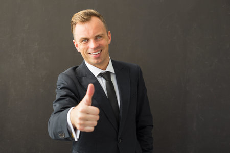 Happy business man showing thumb up