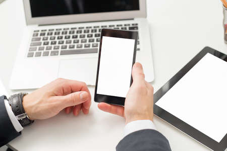 Man holding blank screen smartphone at the officeの写真素材