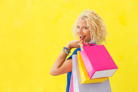 Woman holding swhopping bags over her shoulderの写真素材