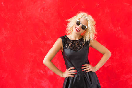 Woman with stylish sunglasses standing with hands on  her hipsの写真素材