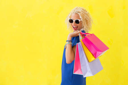 Stylish woman holding shopping bags over her shoulderの写真素材