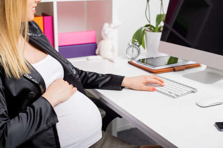 Pregnant woman working on computerの写真素材