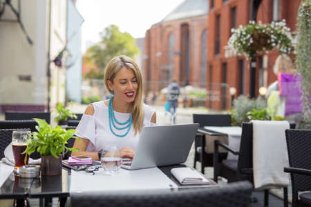 Business woman in cafe working on laptop computerの写真素材