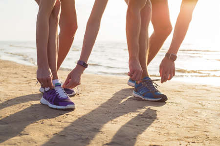 Two runners tying their running shoesの写真素材