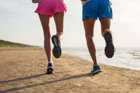 Couple running on the beachの写真素材
