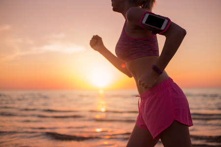 Woman running and listening music on smartphoneの写真素材