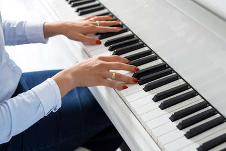 Woman playing white pianoの写真素材