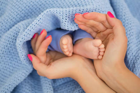 Mother holding her babies little feetの写真素材