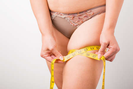 Woman measuring her leg's fatの写真素材
