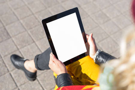 Woman sitting and using blank screen tabletの写真素材