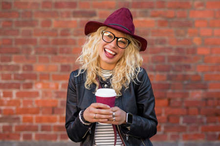 woman standing with coffee cup and smilingの写真素材