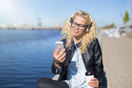 Woman using smartphone to listen to musicの写真素材