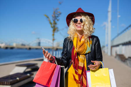 Woman with phone in her hands after shoppingの写真素材